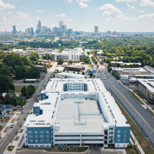 An aerial photo of a large white building with Charlotte, NC skyline in background